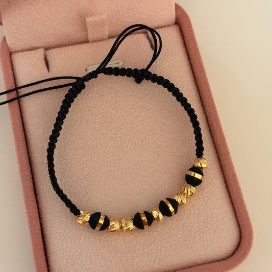 PULSERA HILO NEGRO 8 BOLAS DIAMANTADAS 5MM + NEOROS 6MM 1 RAYA ORO AMARILLO COL 18K - 1,05GR