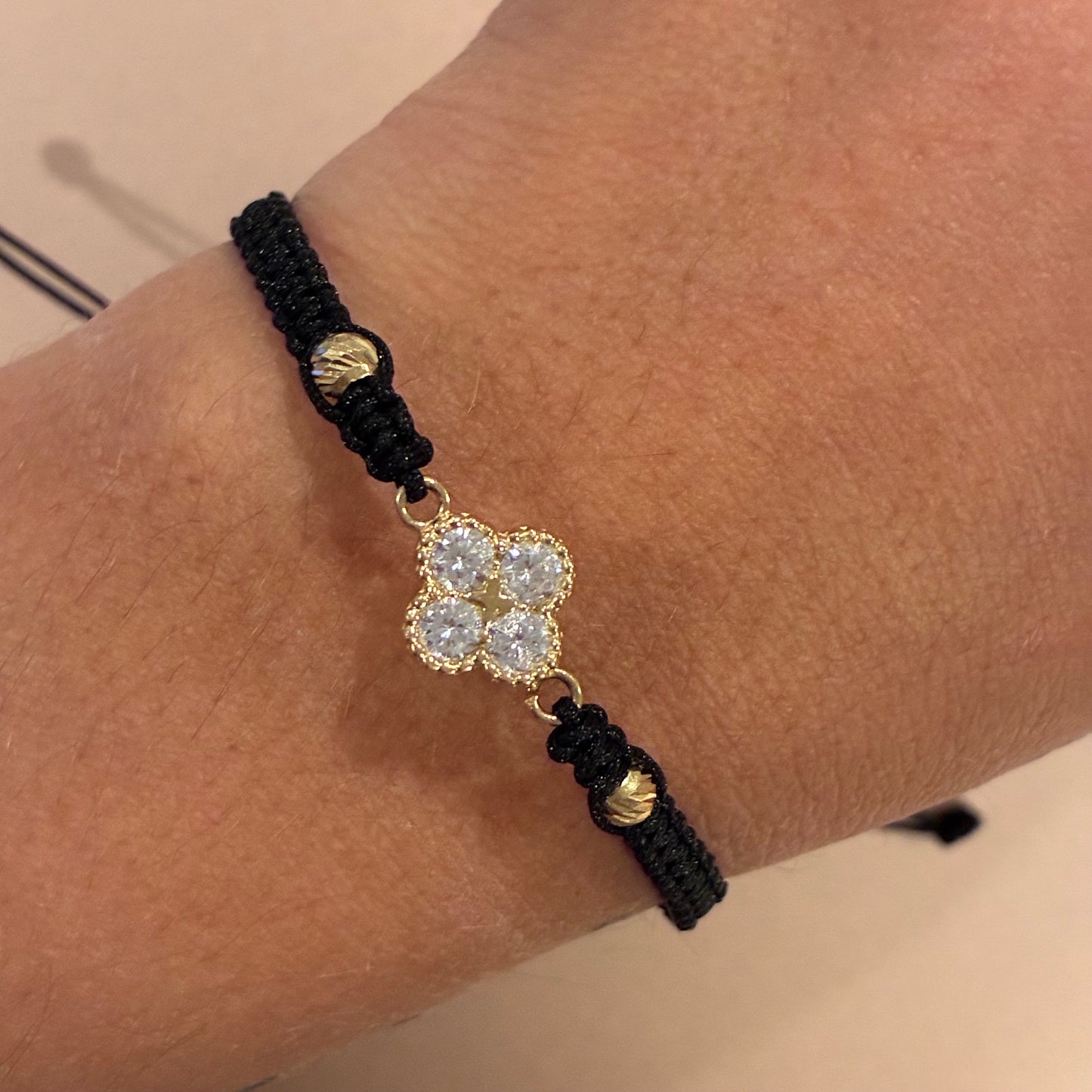 BLACK THREAD BRACELET WITH CLOVER CHARM AND WHITE STONES + 2 DIAMOND-CUT 4M BEADS IN 18K YELLOW GOLD - 1.44GR