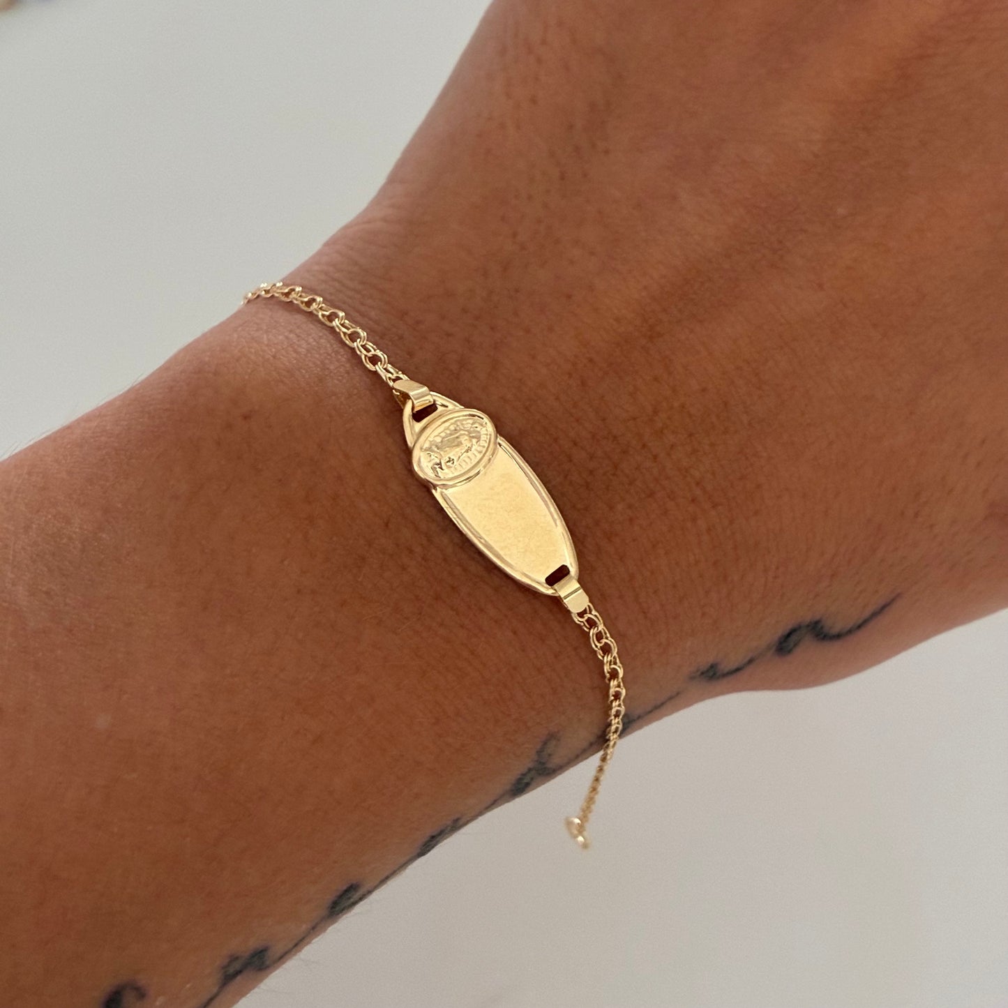 BABY BRACELET WITH OVAL PLAQUE WITH VIRGIN OF GUADALUPE, FOLLOWING RING, 18K YELLOW GOLD, 13.5CM - 1.25GR